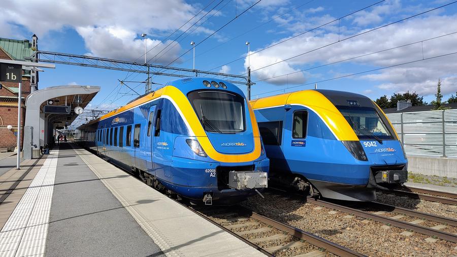 Två Norrtåg vid möts vid en perrong