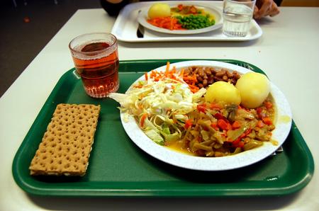 Tallrik med potatis sallad och gryta på matbricka
