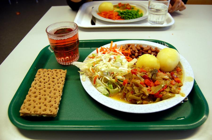 Tallrik med potatis sallad och gryta på matbricka